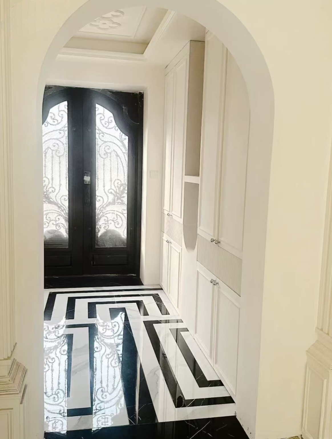 Black and white geometric stone floor in a residential entrance hall